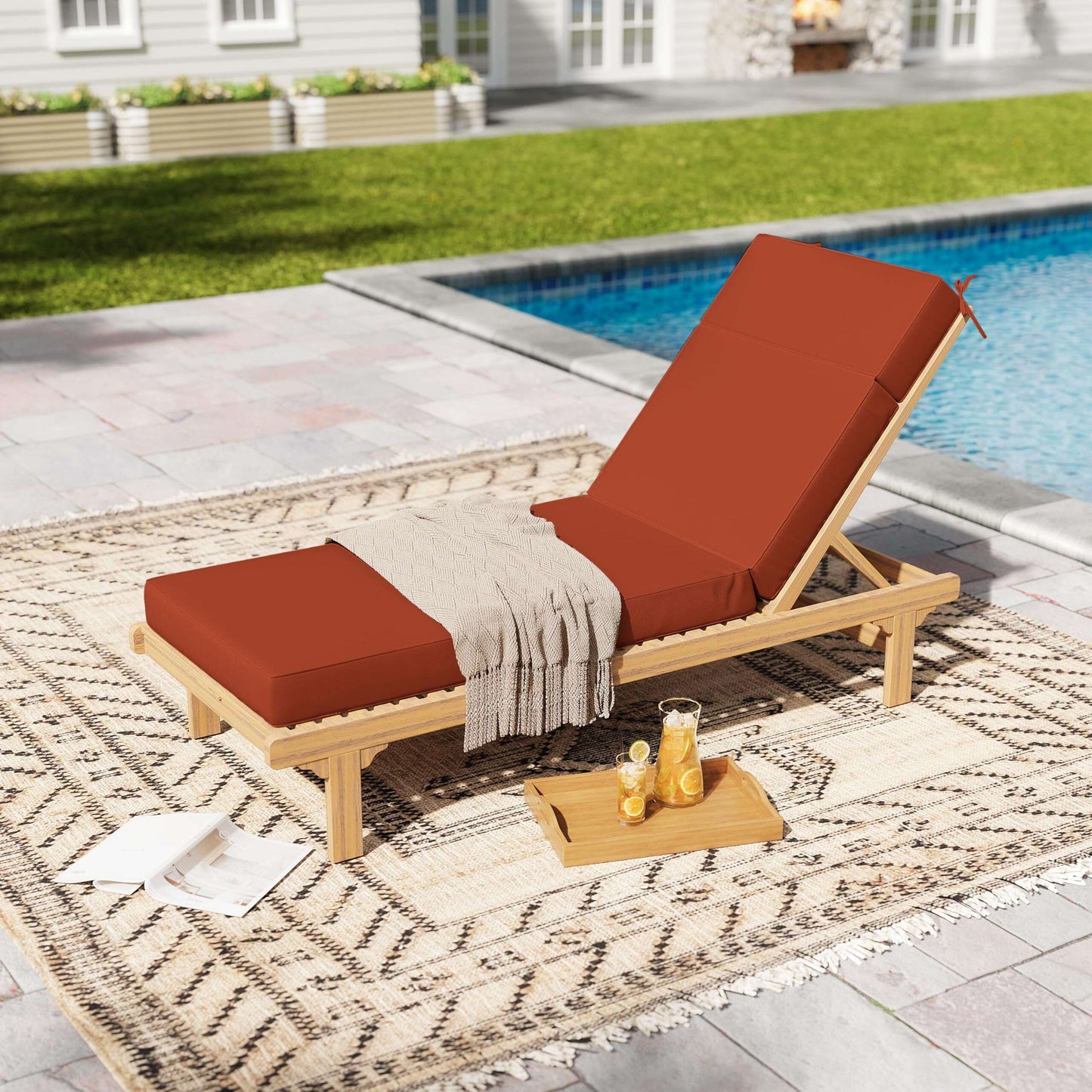 Wooden lounge chair with terra red cushions by a poolside on a patio.