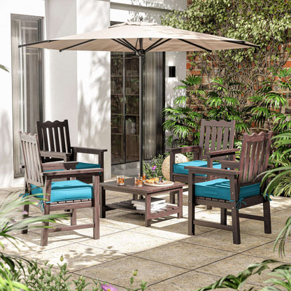 Outdoor patio set with chairs, table, and umbrella on a patio with plants and a building in the background.