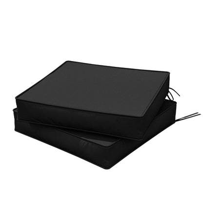 Two stacked black outdoor chair cushions with ties on white background