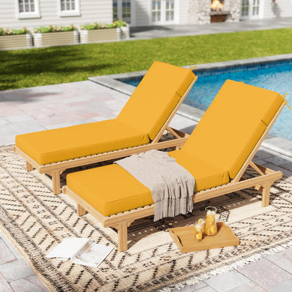 Two yellow outdoor lounge chairs with a small table by a poolside.