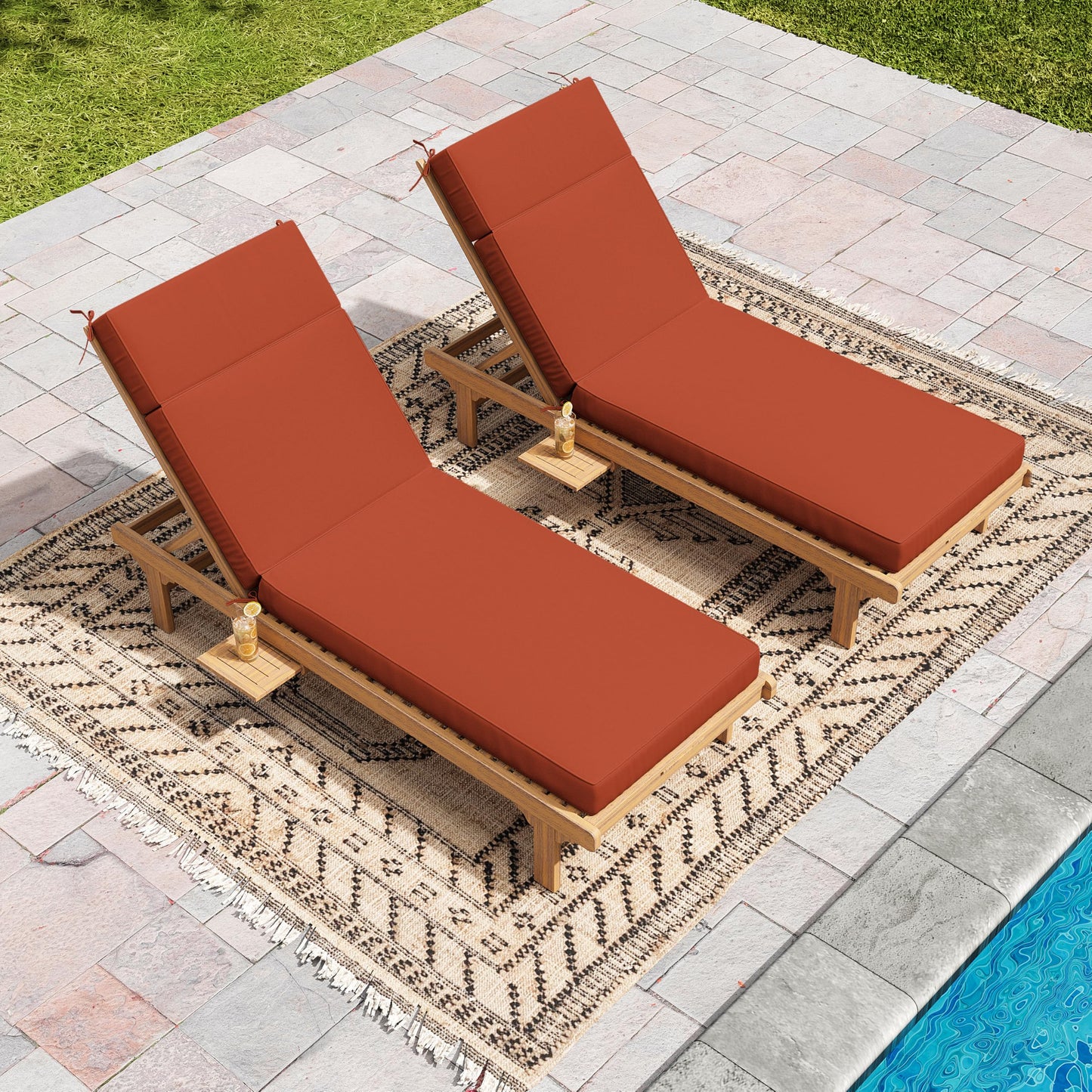 Two wooden lounge chairs with terr red cushions on a patio by a pool.terra