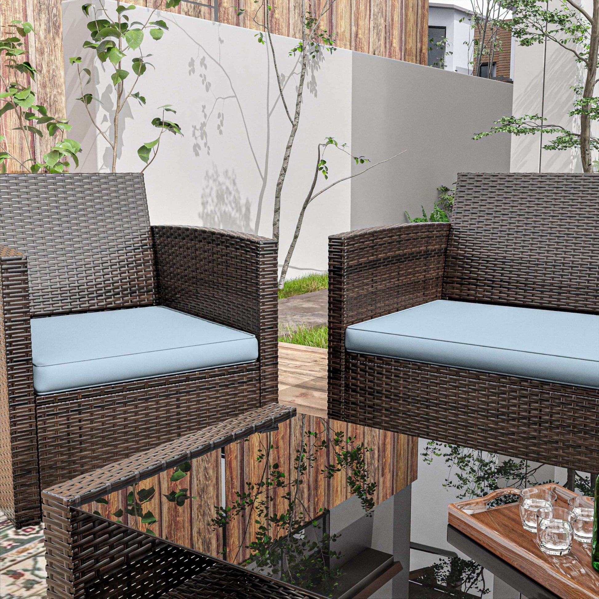 Outdoor patio with brown wicker chairs and blue cushions around a glass coffee table