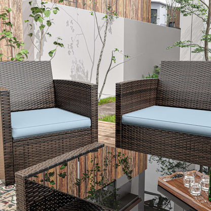 Outdoor patio with brown wicker chairs and blue cushions around a glass coffee table