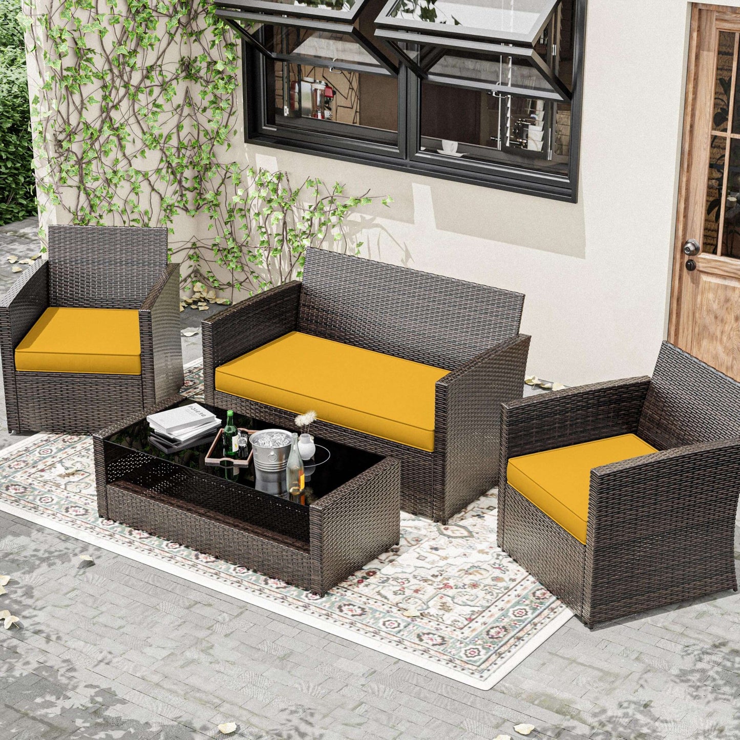 Outdoor patio furniture set with yellow cushions on a patio.
