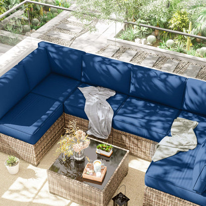 Outdoor patio set with blue cushions and a small table on a patio.