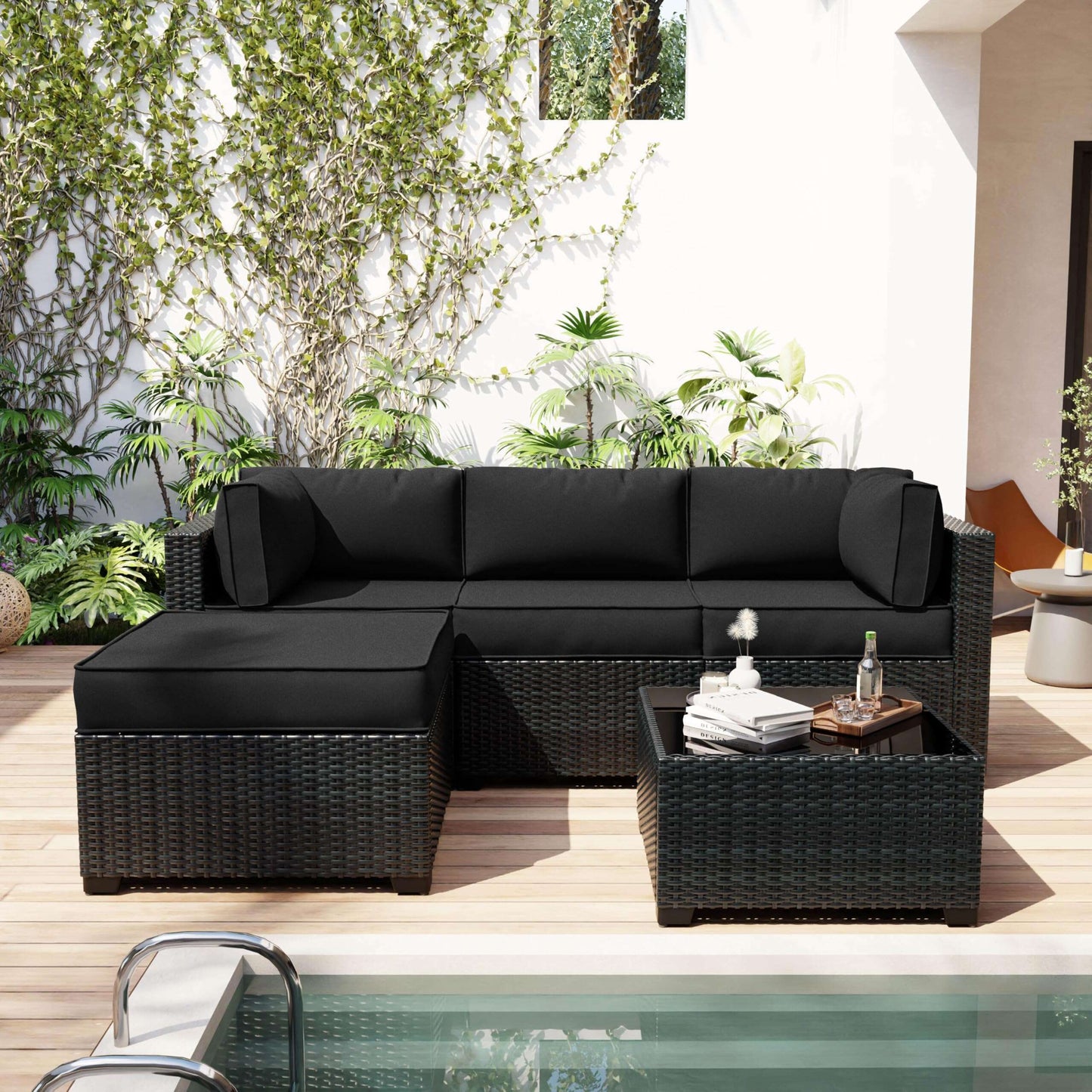 Black outdoor sectional sofa with a small table on a patio with plants in the background