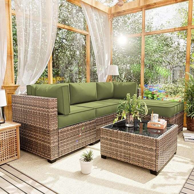Outdoor patio set with green cushions and a glass table in a sunroom.