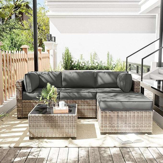 Outdoor patio furniture set with gray cushions on a wooden deck.