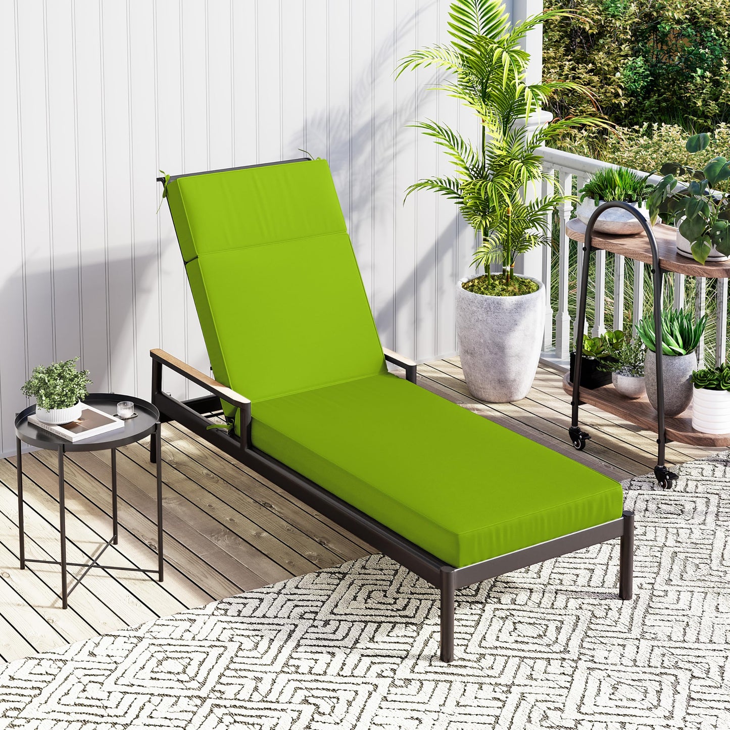 Green outdoor lounge chair on a patio with plants and a small table.