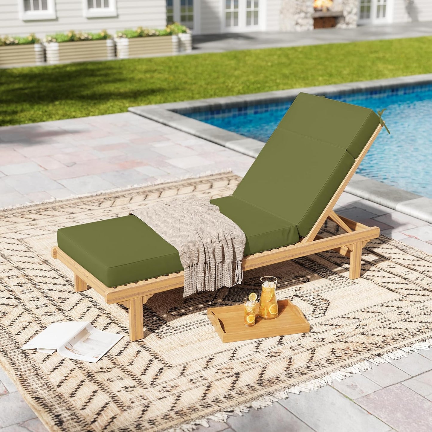 Wooden lounge chair with green cushions by a poolside