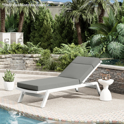 Gray cushioned lounge chair on a patio with pool and garden view