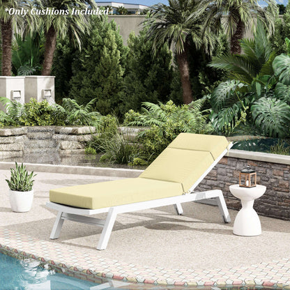 Outdoor lounge chair with yellow cushions on a patio near a pool, surrounded by greenery.
