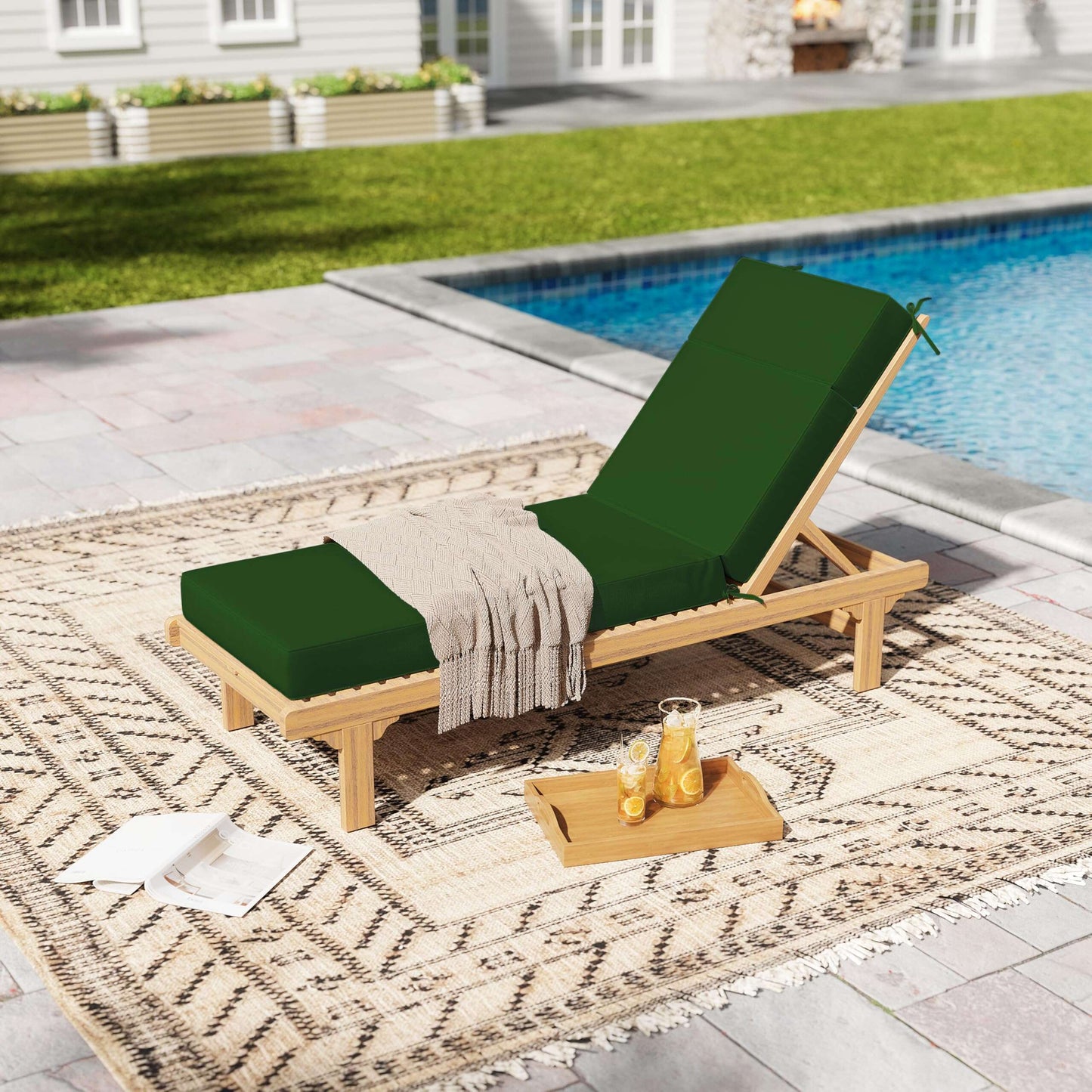 Wooden lounge chair with green cushions by a poolside on a patterned rug.