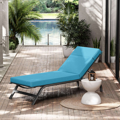 Blue lounge chair on a wooden deck with plants and a pool in the background