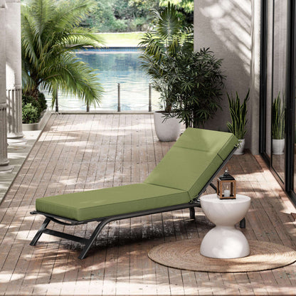 Green outdoor lounge chair on a wooden deck with plants and a pool view.