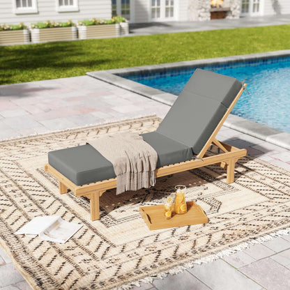 Wooden lounge chair with gray cushions by a poolside on a patterned rug