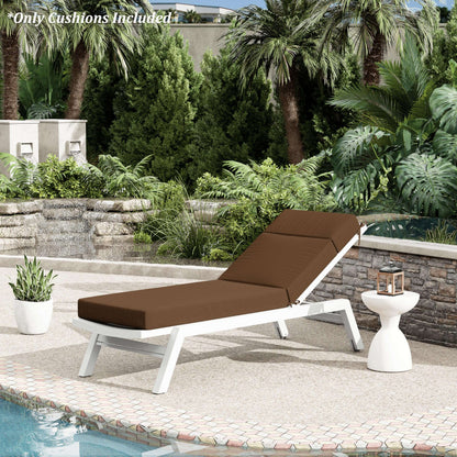 Brown cushioned lounge chair by a pool with palm trees and garden in the background