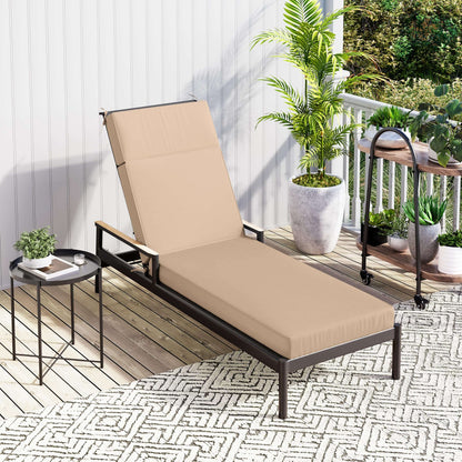 Beige cushion on outdoor lounge chair on a patio with plants and a small table.