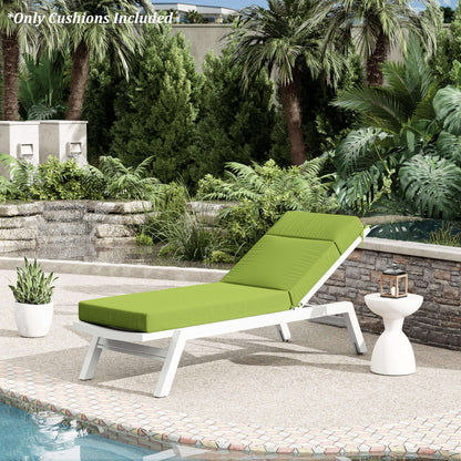 Green cushioned lounge chair on a patio with pool and garden view
