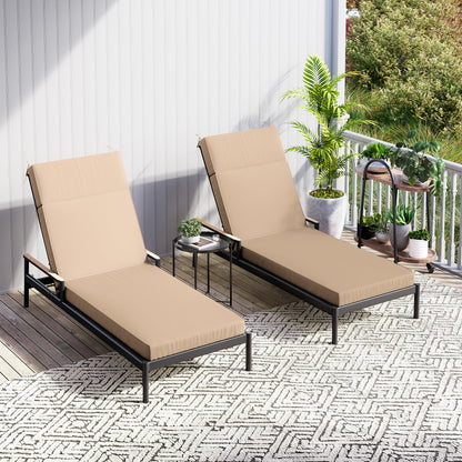 Two beige lounge chairs on a patio with plants and a small table.