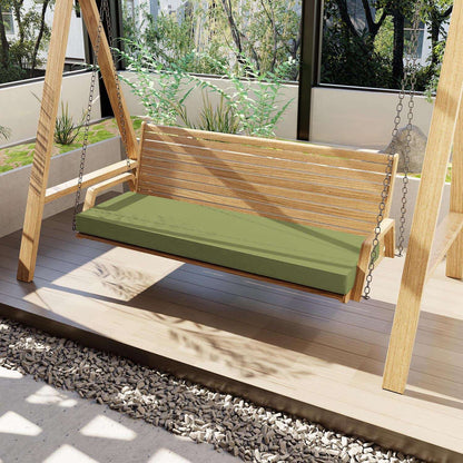Wooden swing with green cushion on a wooden deck