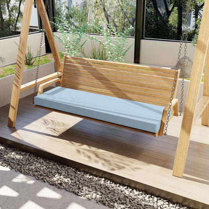 Wooden swing with a blue cushion on a wooden platform in an outdoor setting.
