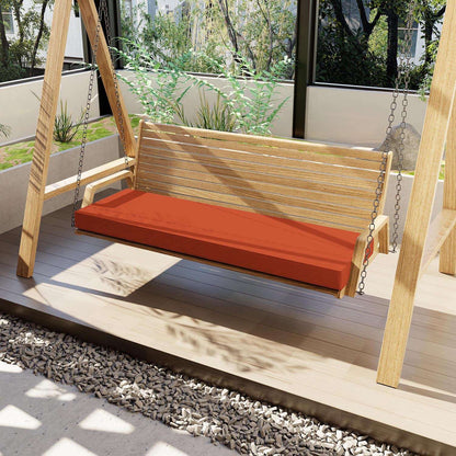 Wooden swing with an orange cushion on a wooden deck
