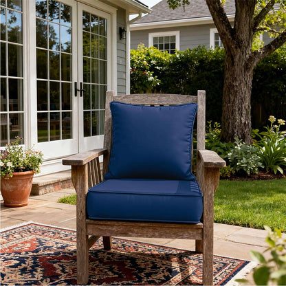 Wooden chair with blue cushions on a patio, surrounded by garden elements.