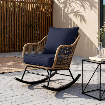 Rattan rocking chair with navy cushions on a patio