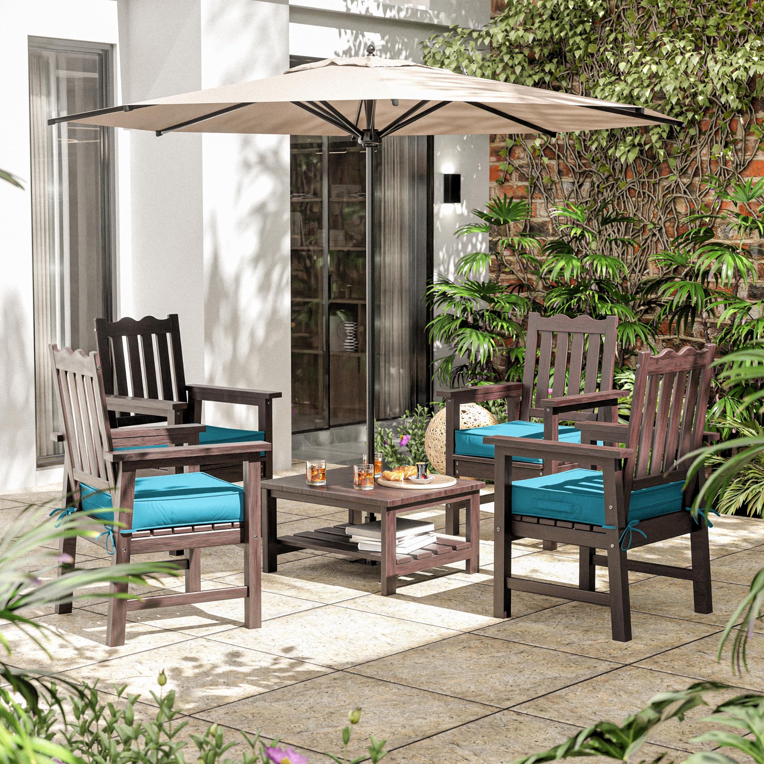 Outdoor patio set with chairs, table, and umbrella on a patio with plants and a building in the background.