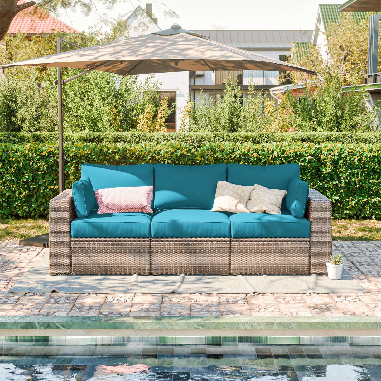 Outdoor sofa with blue cushions under an umbrella by a poolside