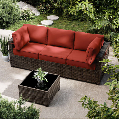 Outdoor patio set with red cushions and a small table in a garden setting.