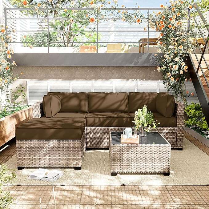 Brown outdoor sectional sofa with a coffee table on a patio with plants and flowers.