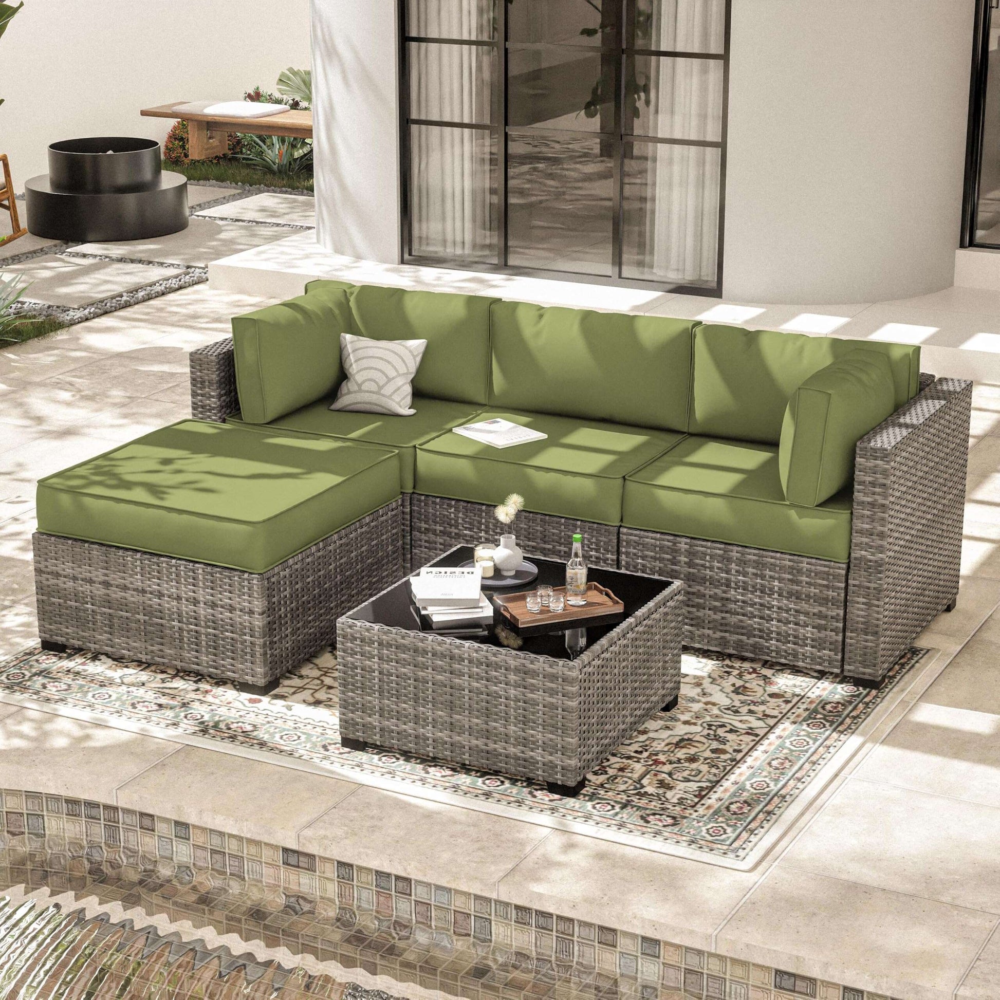 Outdoor patio with modern wicker sectional sofa with green cushions and a matching wicker coffee table on patterned rug
