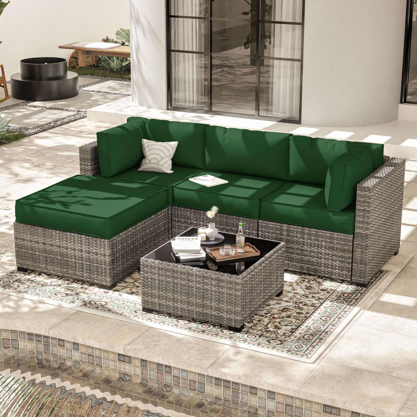 Modern patio with gray wicker sectional sofa featuring green cushions and a matching coffee table on patterned rug
