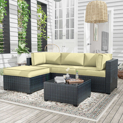Outdoor black rattan 4-seater sofa set with beige cushions on patterned rug in patio setting