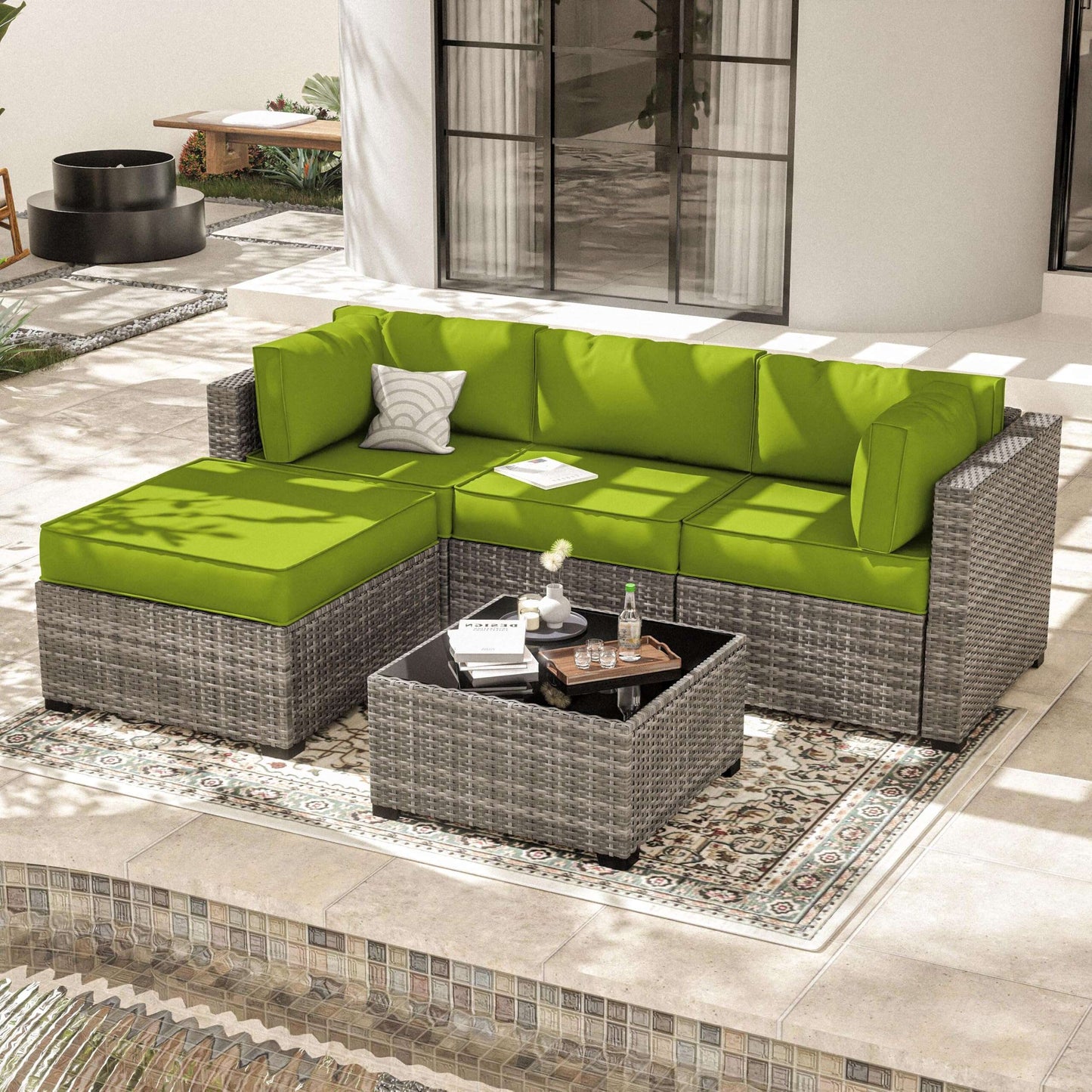 Outdoor patio with grey wicker sectional sofa featuring bright green cushions and a matching coffee table on a patterned rug