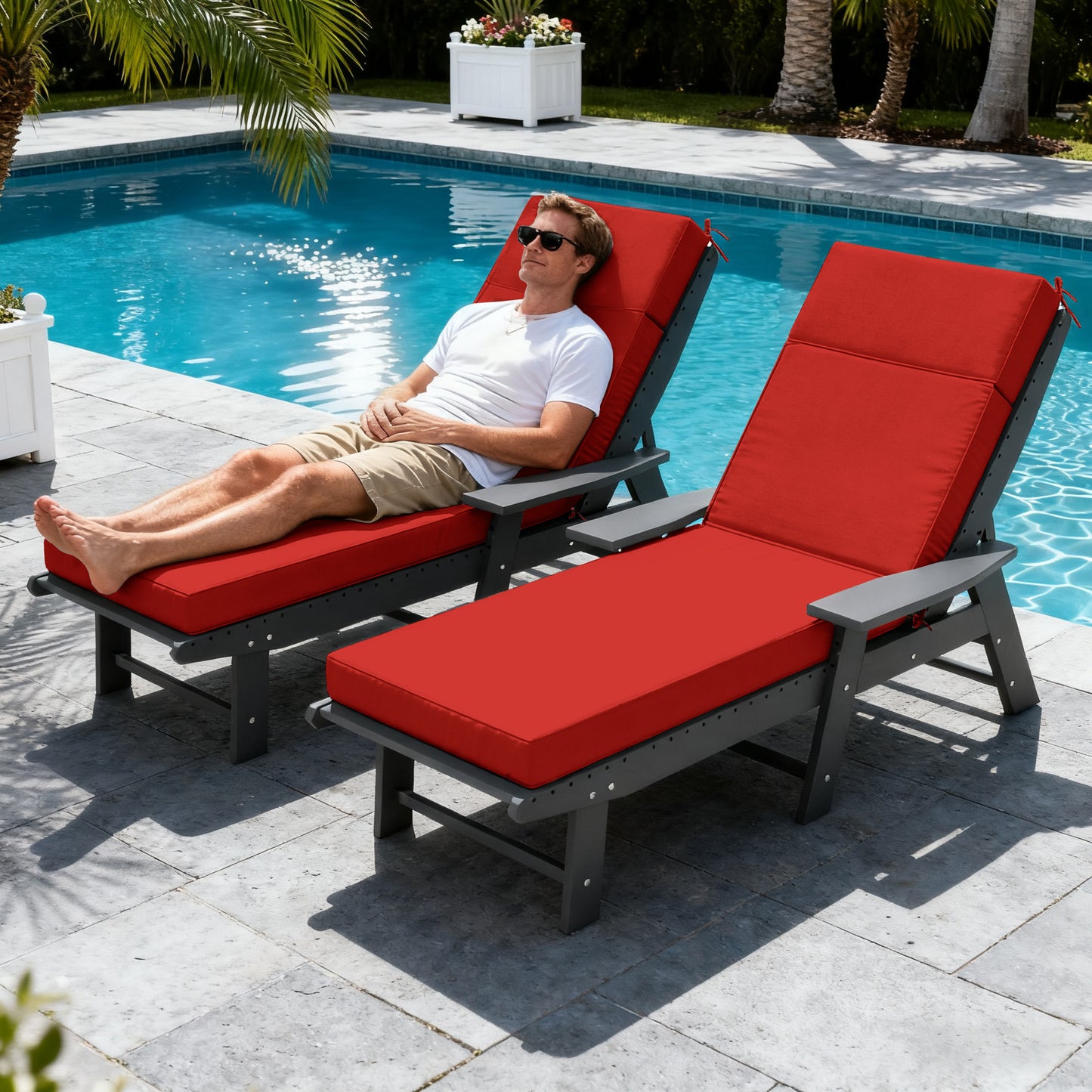 Man relaxing on a red outdoor lounge chair by a pool