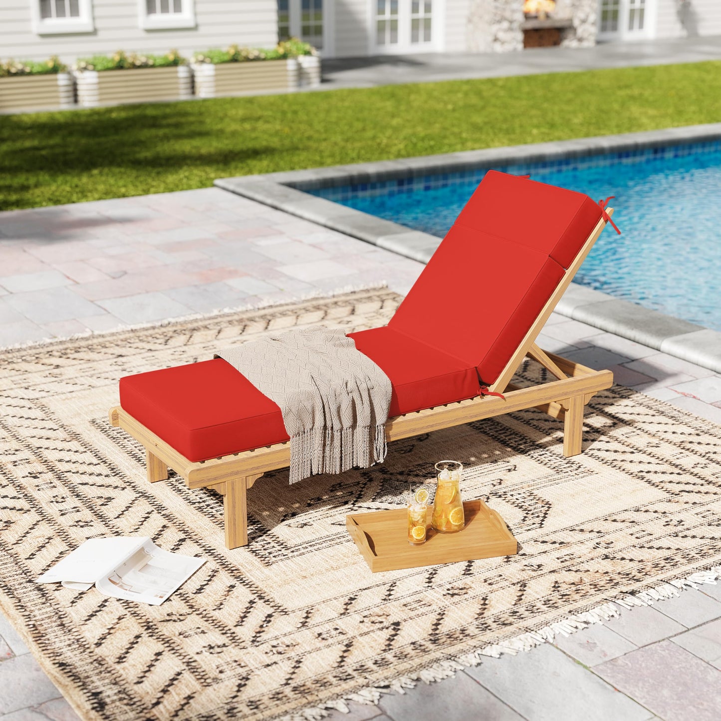 Wooden lounge chair with red cushions by a poolside on a patio.