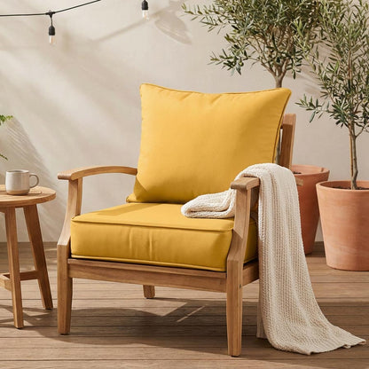 yellow cushion and pillow on a wooden chair with a blanket in the patio